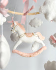 Mobile with a white rocking horse and a pink bow