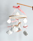 Mobile with a white rocking horse and a pink bow