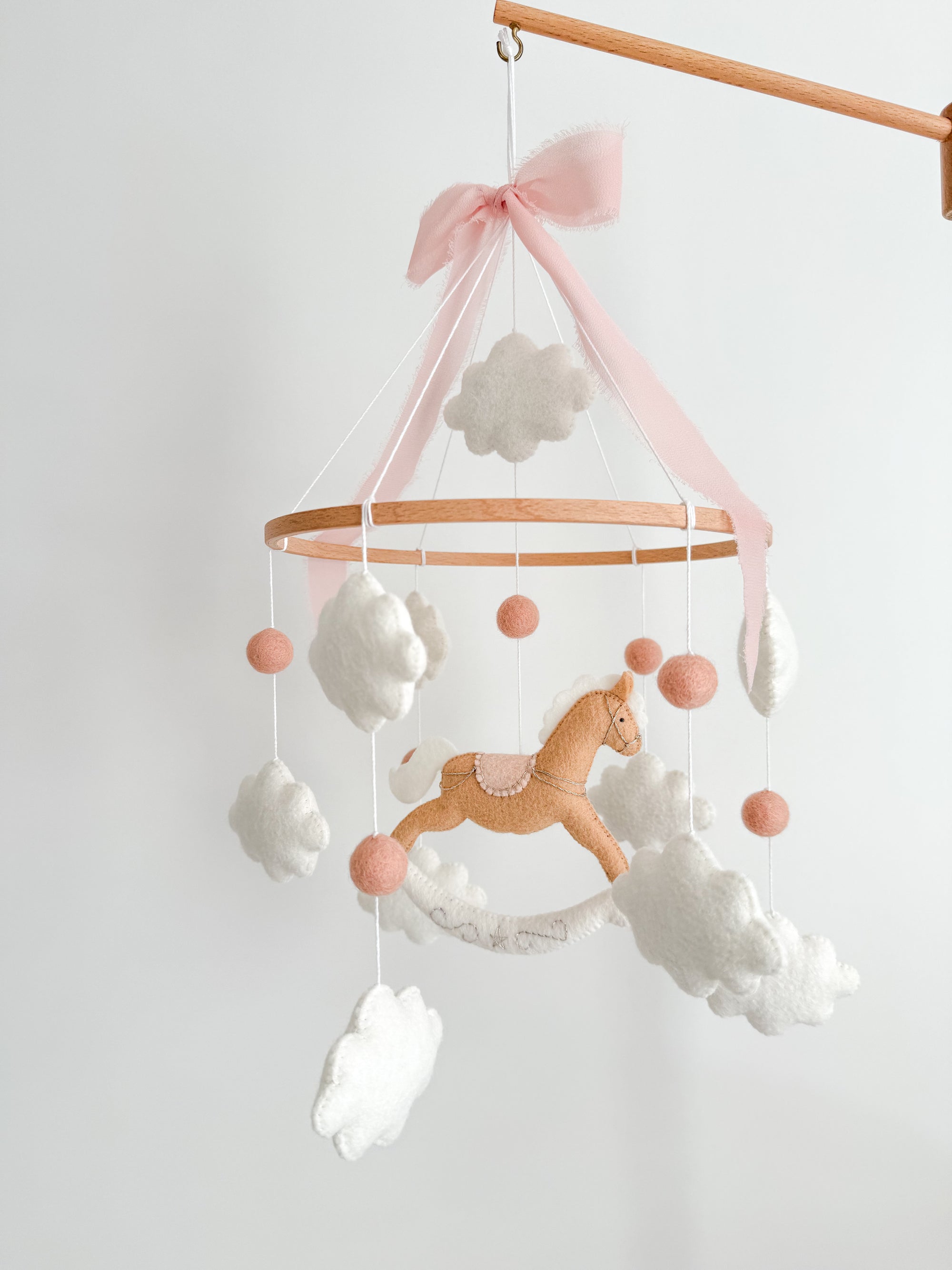 Mobile with a brown rocking horse and pink bow
