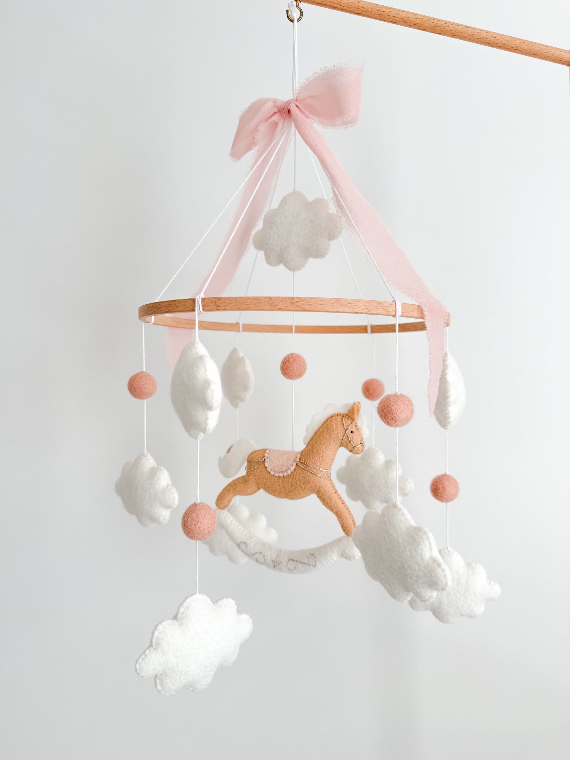 Mobile with a brown rocking horse and pink bow