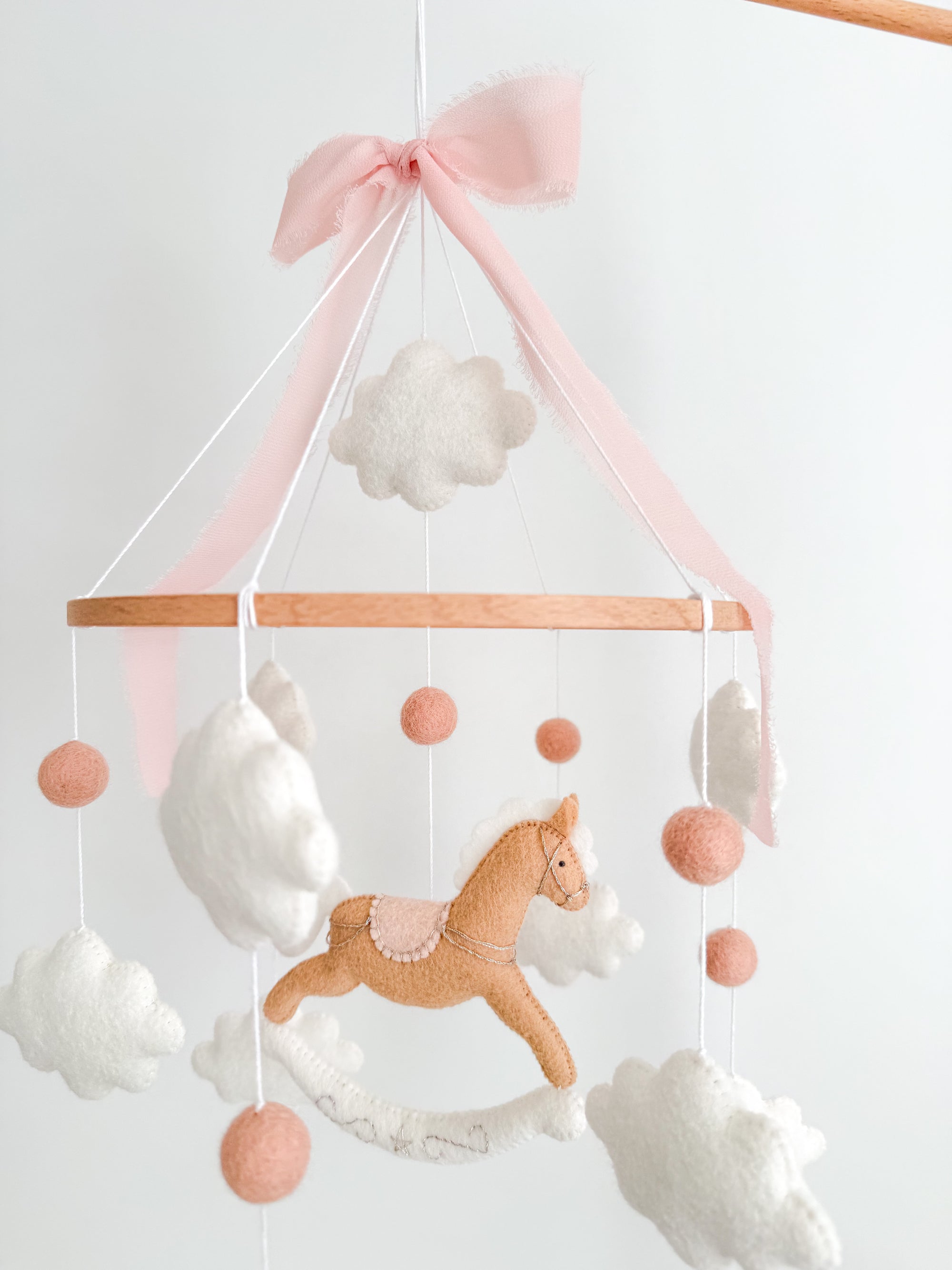 Mobile with a brown rocking horse and pink bow