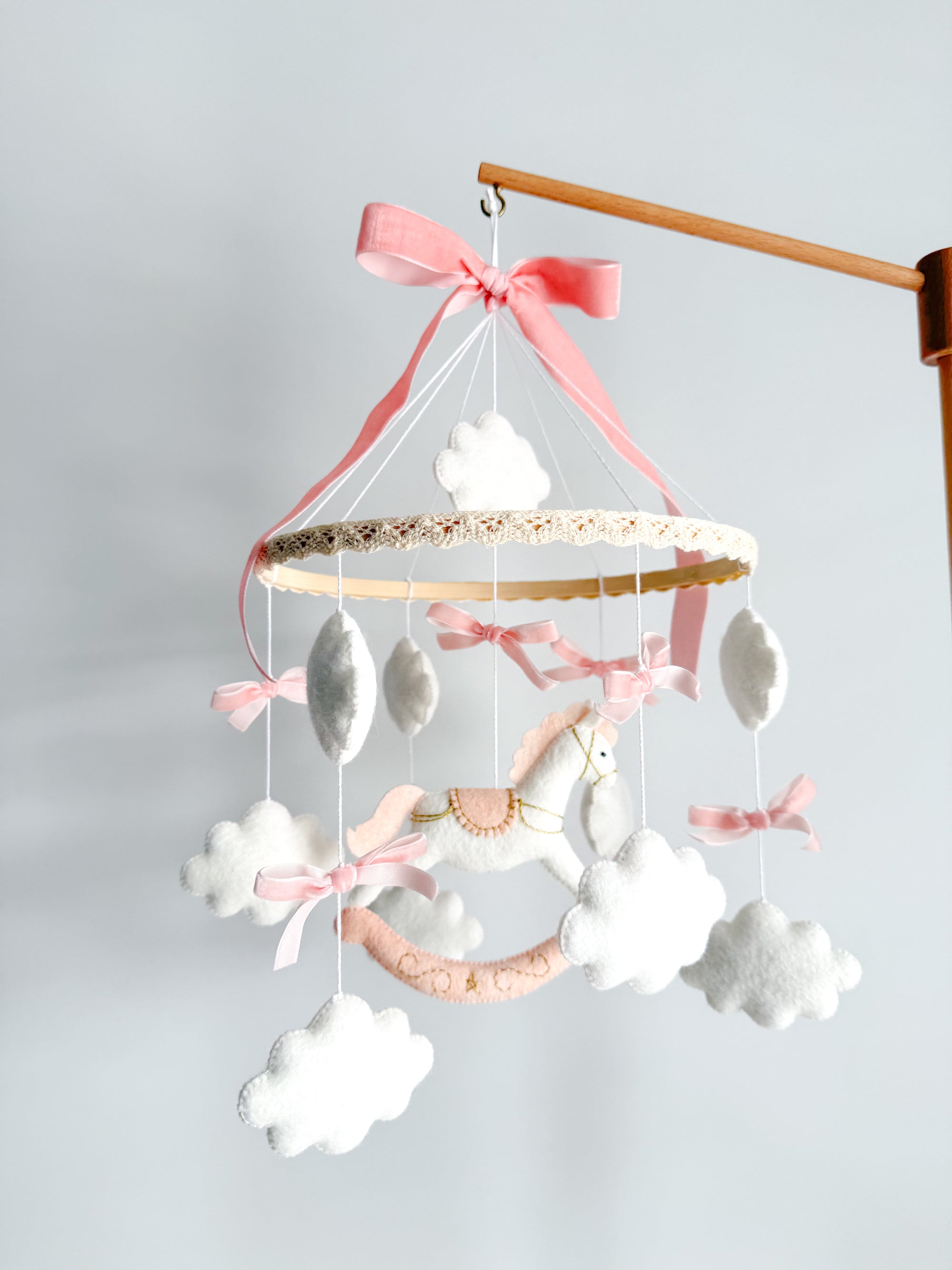 Mobile with a white rocking horse and a pink bow