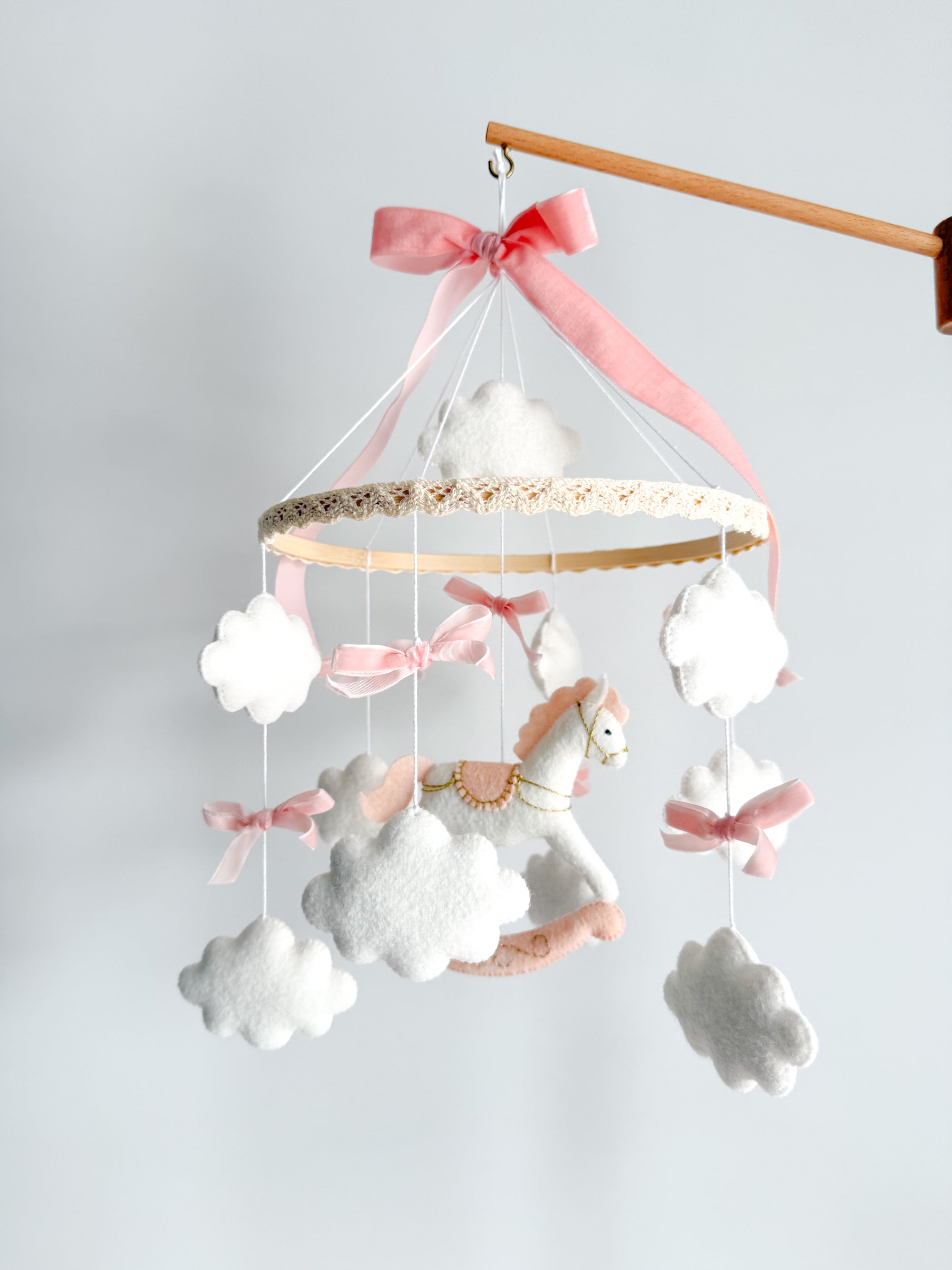 Mobile with a white rocking horse and a pink bow