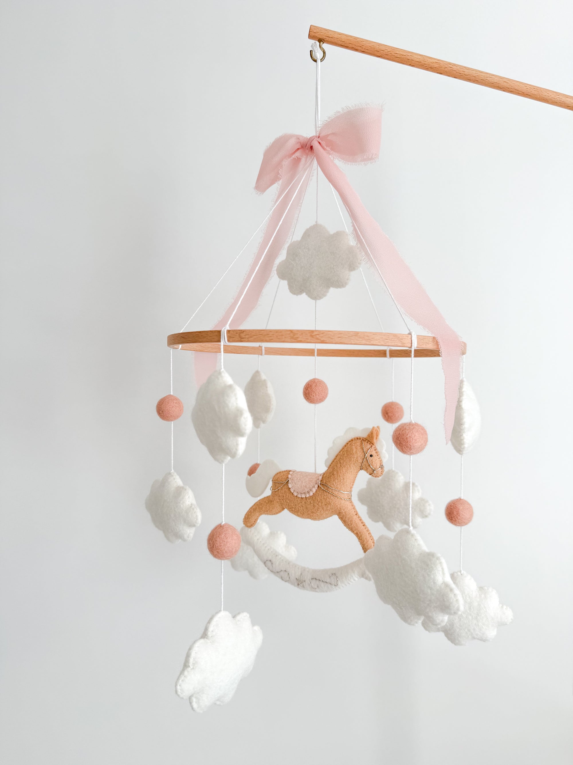 Mobile with a brown rocking horse and pink bow