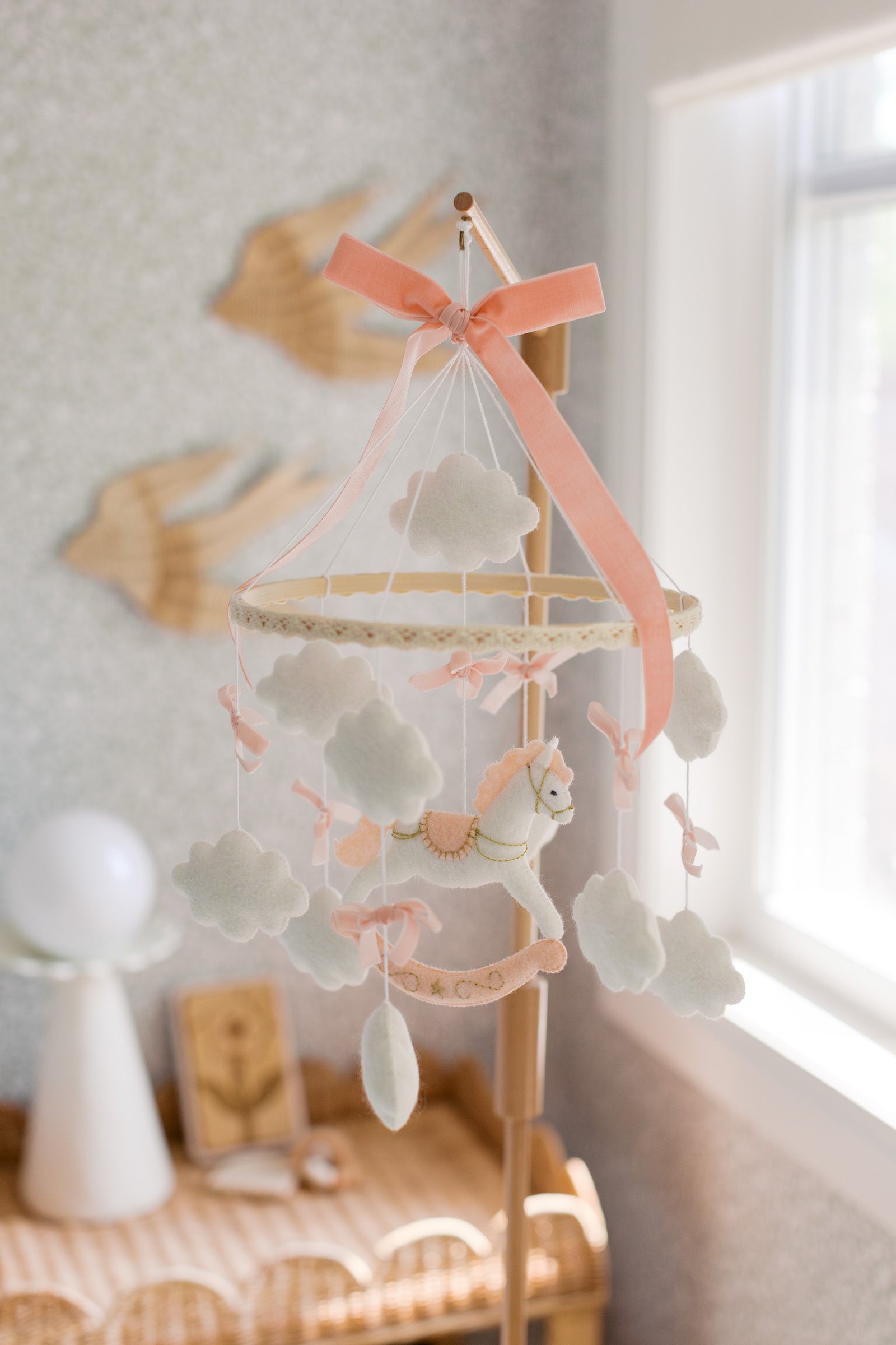 Mobile with a white rocking horse and a pink bow