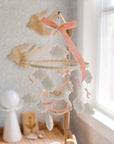 Mobile with a white rocking horse and a pink bow