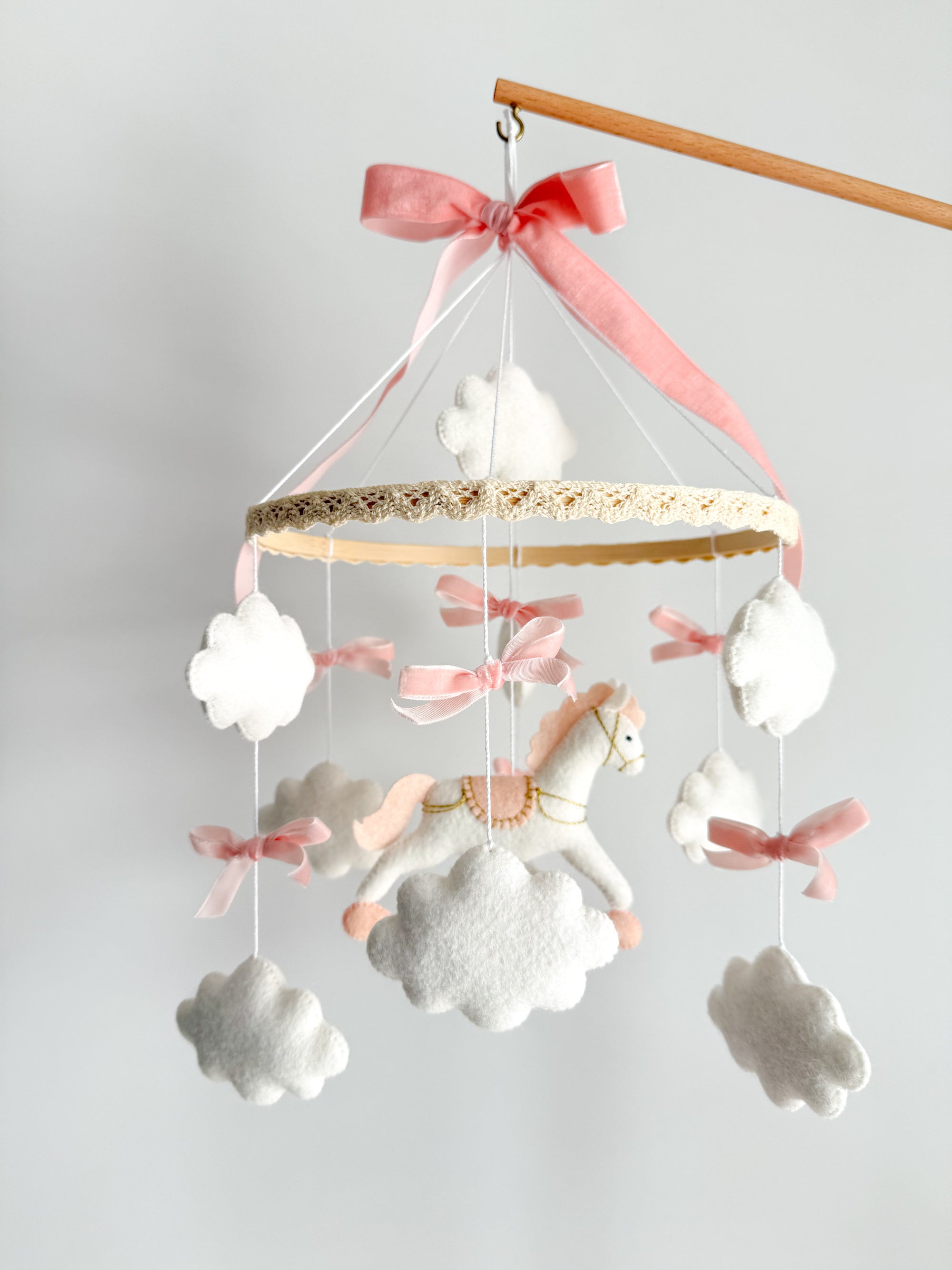 Mobile with a white rocking horse and a pink bow