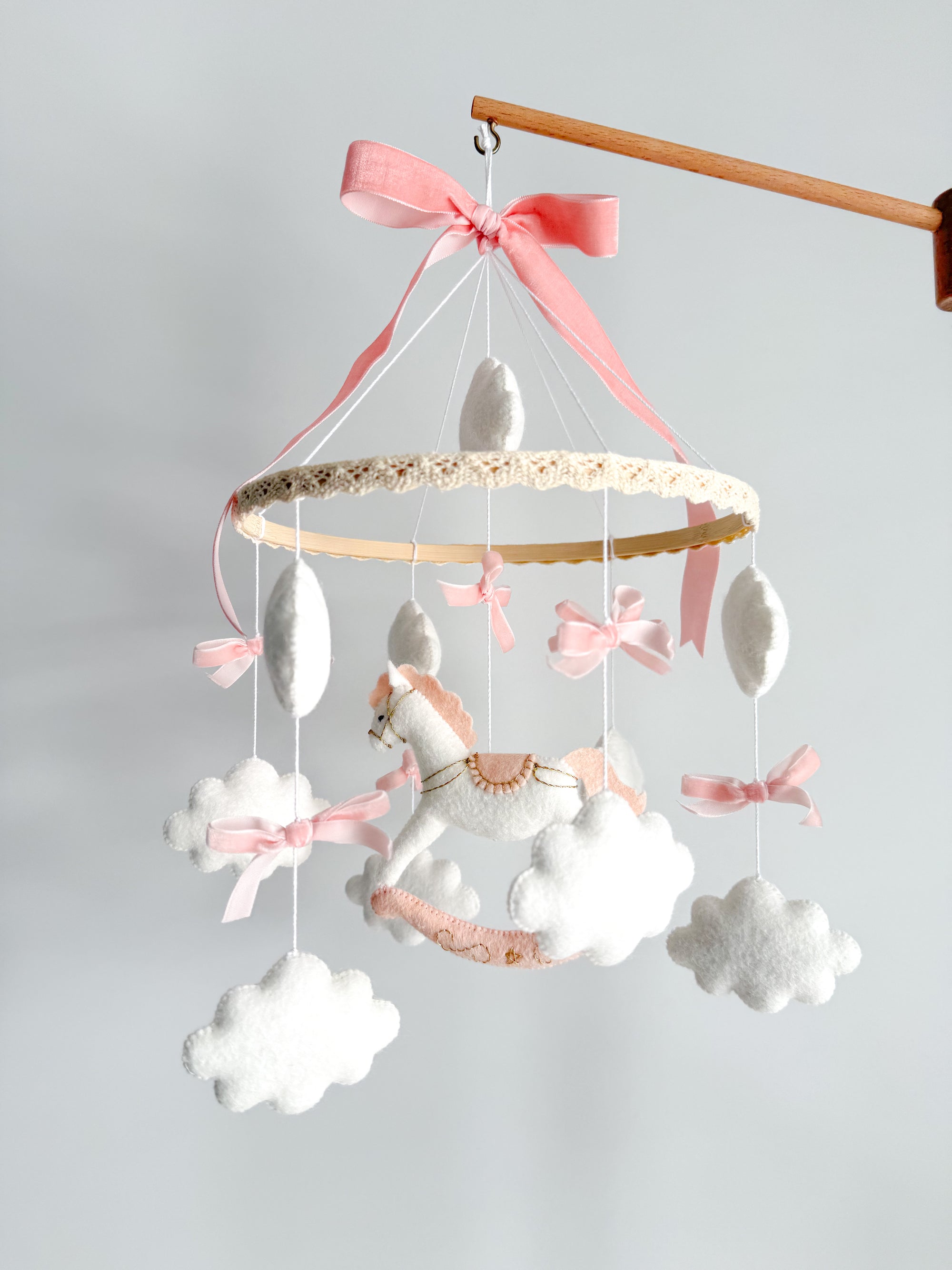Mobile with a white rocking horse and a pink bow