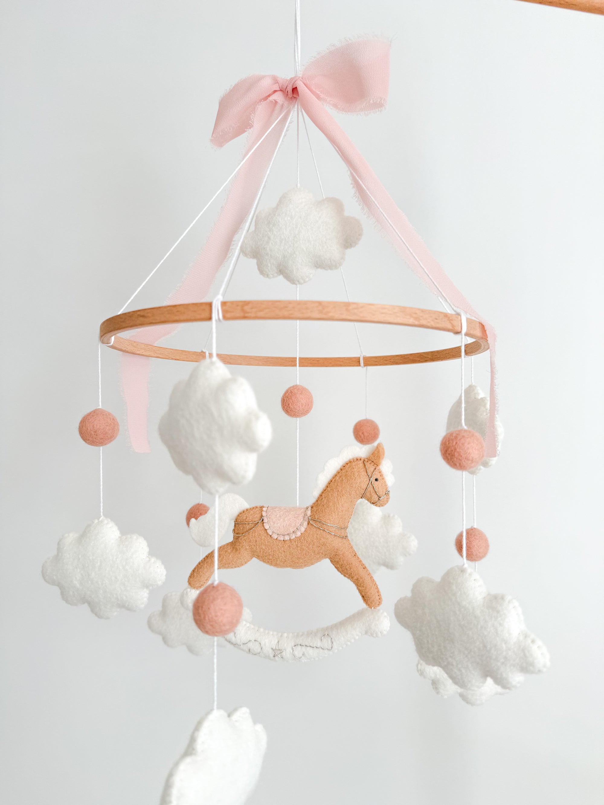 Mobile with a brown rocking horse and pink bow
