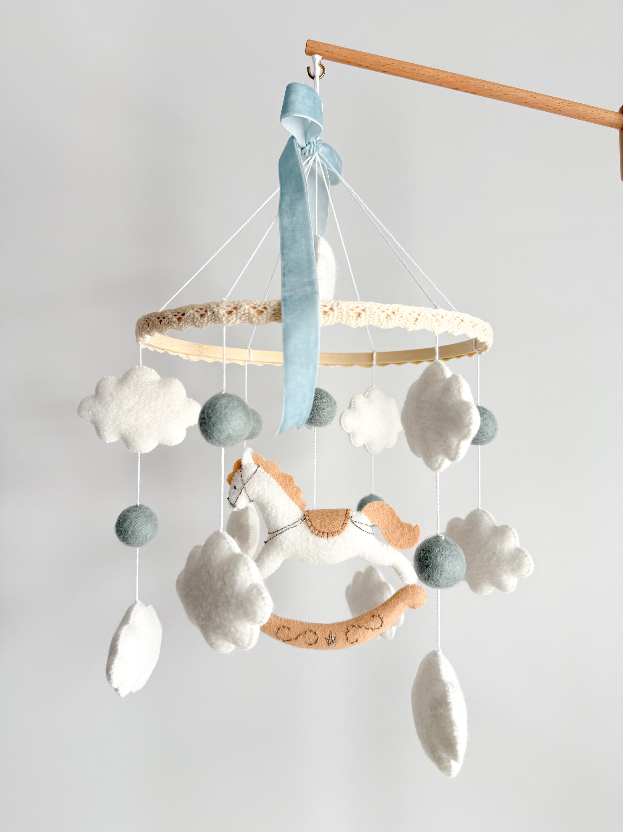 Mobile with a white rocking horse and a blue bow