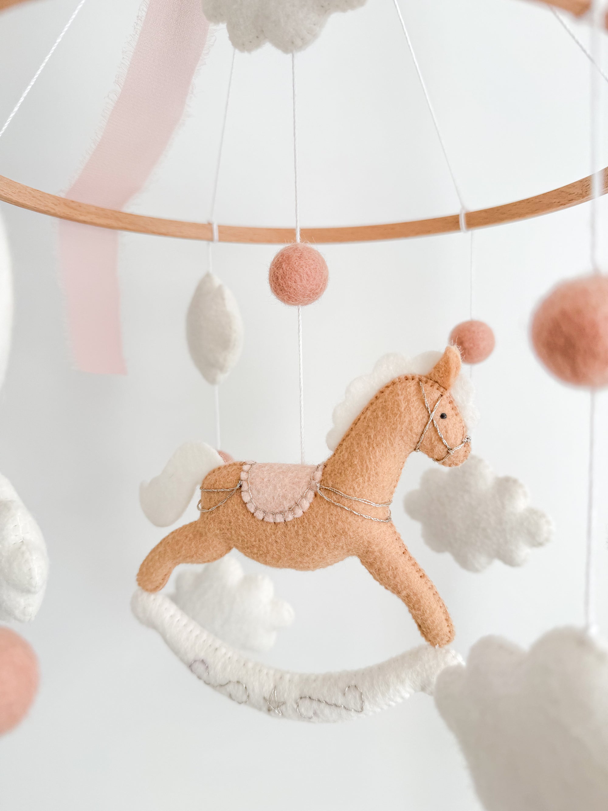 Mobile with a brown rocking horse and pink bow